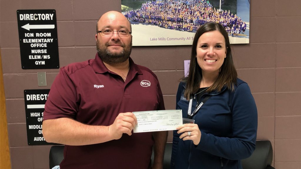 Casey Singelstad, Lichtsinn RV Controller and HR Manager, presents WE CARE Charitable Giving Check to Lake Mills Community School District School Board President